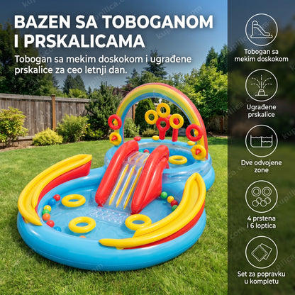 Plavo-crveno-žuti bazen sa toboganom i prskalicama u dvorištu popodne