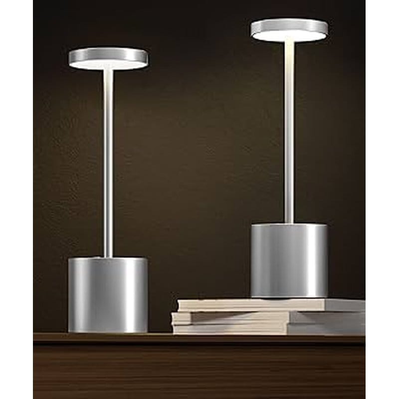 dve sive led stone lampe na drvenoj polici, jedna postavljena na knjige
