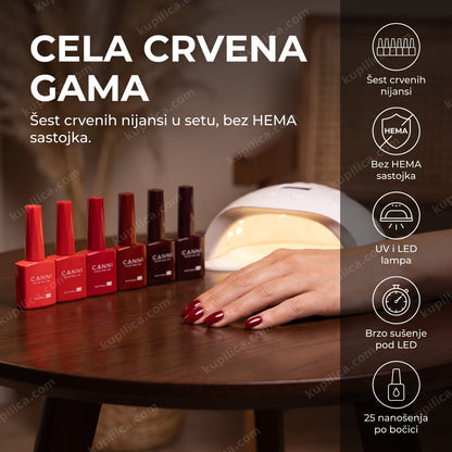 canni gel lak set 2309 crveni — ruka sa crvenim gel lak manikirom i šest CANNI bočica pored LED lampe, šest crvenih nijansi, bez hema sastojka, uv i led lampa