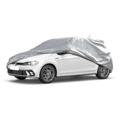 navlačenje cerade preko belog automobila parkiranog ispred kuće