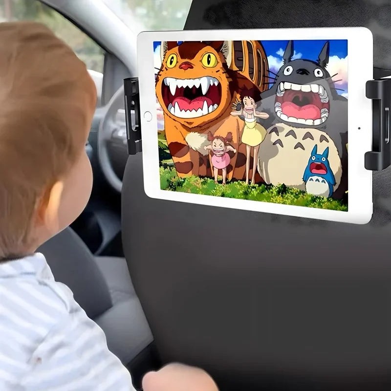 dete gleda crtani film sa likovima Totoro na tabletu montiranom na naslon sedišta u automobilu