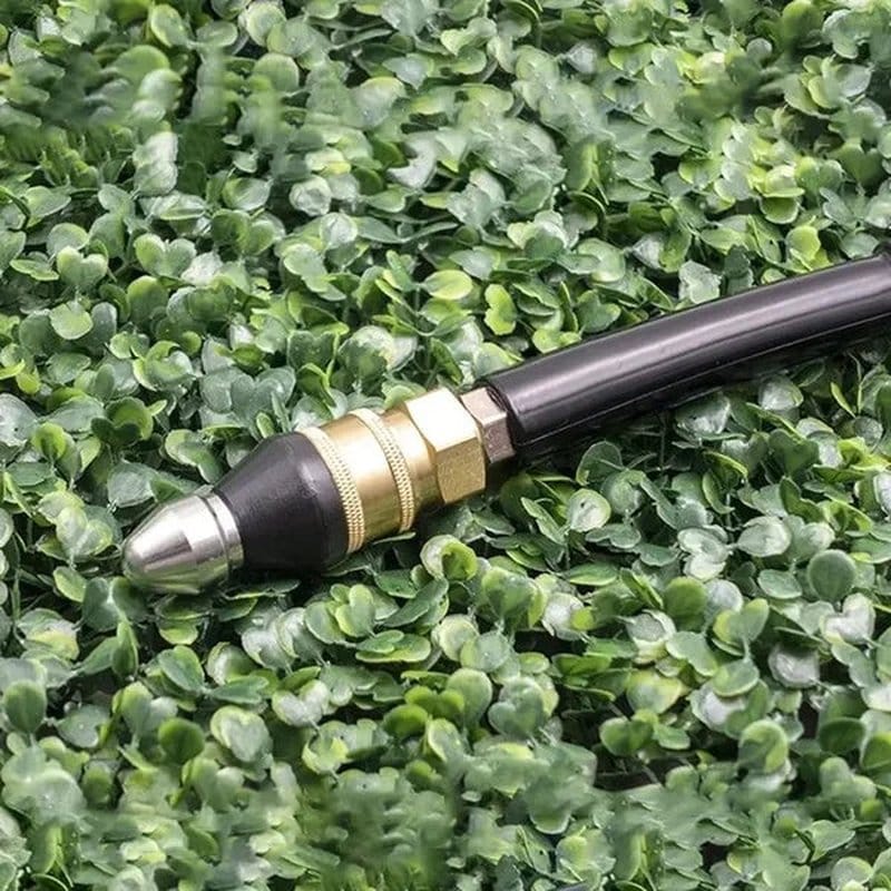 alat za čišćenje cevi flowfixer priključen na crevo položen na veštačku travu