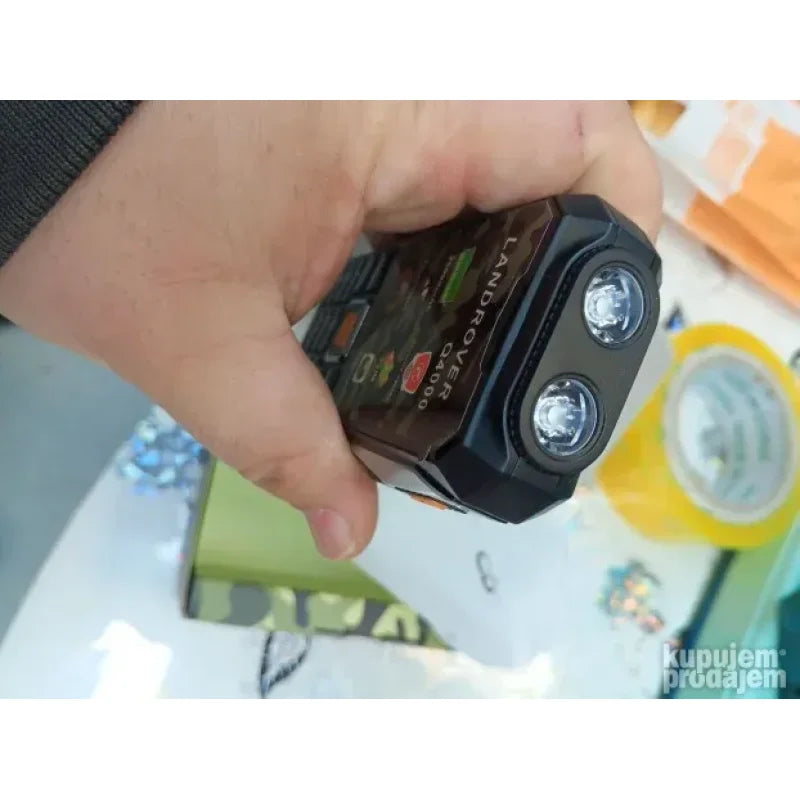 gornja strana telefona sa upaljenom LED lampom u ruci korisnika
