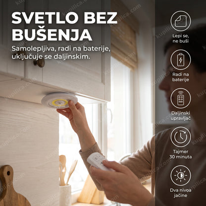 led lampa na baterije sa daljinskim — osoba lepi okruglu led lampu ispod kuhinjskog elementa i drži daljinski
