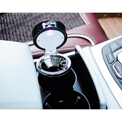 Pepeljara sa podignutim poklopcem u držaču za čaše pored centralne konzole automobila