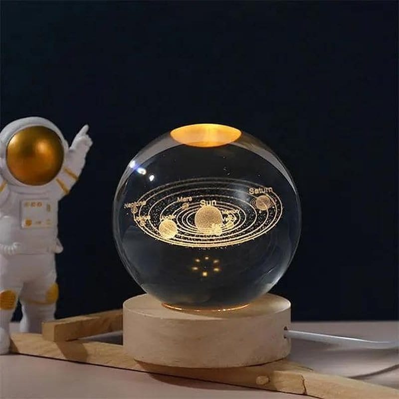 LED sfera Lumaball pored figure astronauta na drvenom postolju