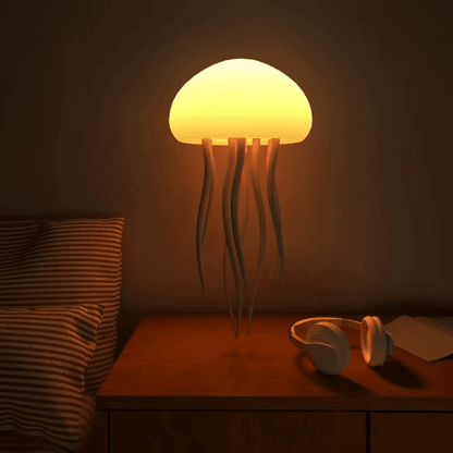 meduza lampa na komodi pored slušalica u toploj spavaćoj sobi