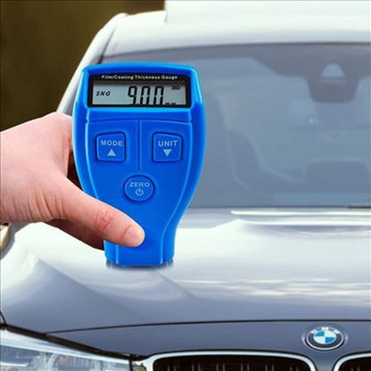 ruka drži merač debljine farbe na haubi BMW automobila