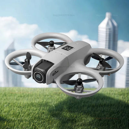sivi dron sa kamerom leti iznad trave sa zgradama u pozadini