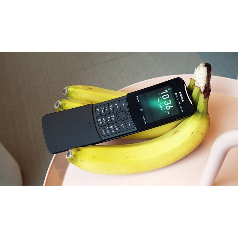 nokia 8110 banana telefon crne boje naslonjen na gomilu žutih banana