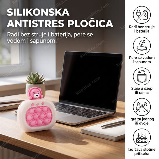 Roze pop it antistres pločica na radnom stolu pored ugašenog laptopa