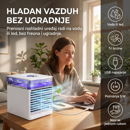 Mini klima Arctic Air Newfan — odrasla osoba sedi za radnim stolom ispred prenosnog rashladnog uređaja punjenog vodom, USB kabl priključen na laptop