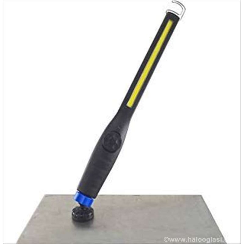 lampa u obliku olovke sa žutom COB diodom stoji na metalnoj površini preko plavog magneta