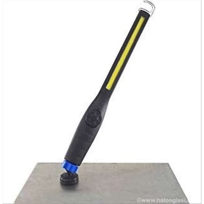 lampa u obliku olovke sa žutom COB diodom stoji na metalnoj površini preko plavog magneta