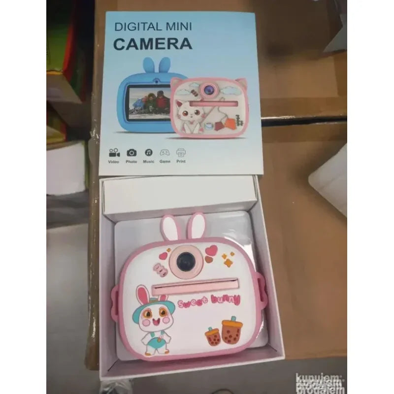 roze fotoaparat sa štampačem pored USB kabla za punjenje
