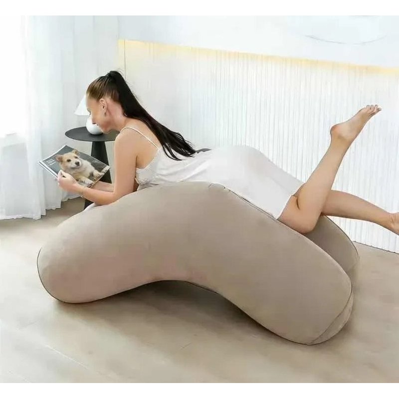 sofa na naduvavanje u sobi, žena leži potrbuške i čita pored psa na slici