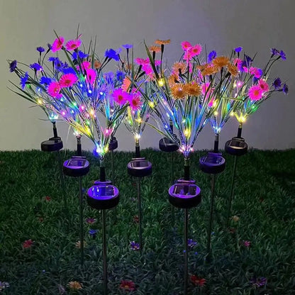 Solarne lampe gerberi sa šarenim LED diodama svetle noću u travi