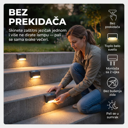 solarne led lampe za ogradu set od 4 komada — žena montira lampe pored betonskih stepenica u sumrak, toplo belo svetlo, bez prekidača
