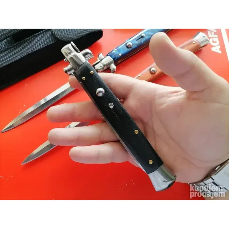Stiletto nož skakavac i futrola raspoređeni na drvenoj podlozi