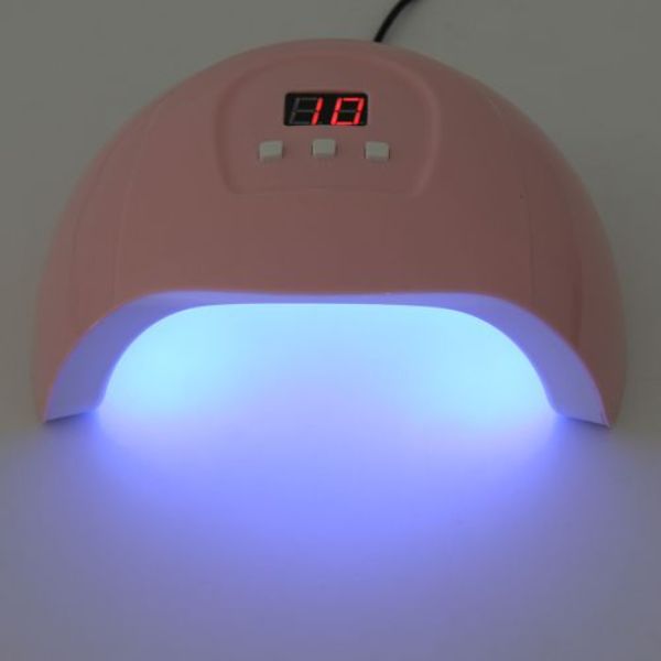 uv lampa za nokte upaljena, ljubičasto svetlo iz otvora i ekran pokazuje 10 sekundi do kraja