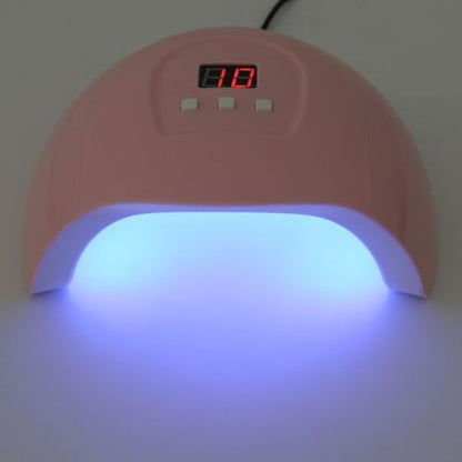 uv lampa za nokte upaljena, ljubičasto svetlo iz otvora i ekran pokazuje 10 sekundi do kraja