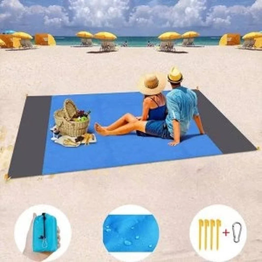 vodootporna prostirka za kampovanje i plažu prostrta na pesku sa parom koja sedi